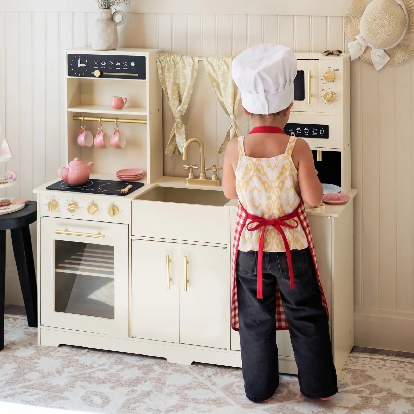 Tiny Land cream wooden play kitchen shown in a play space